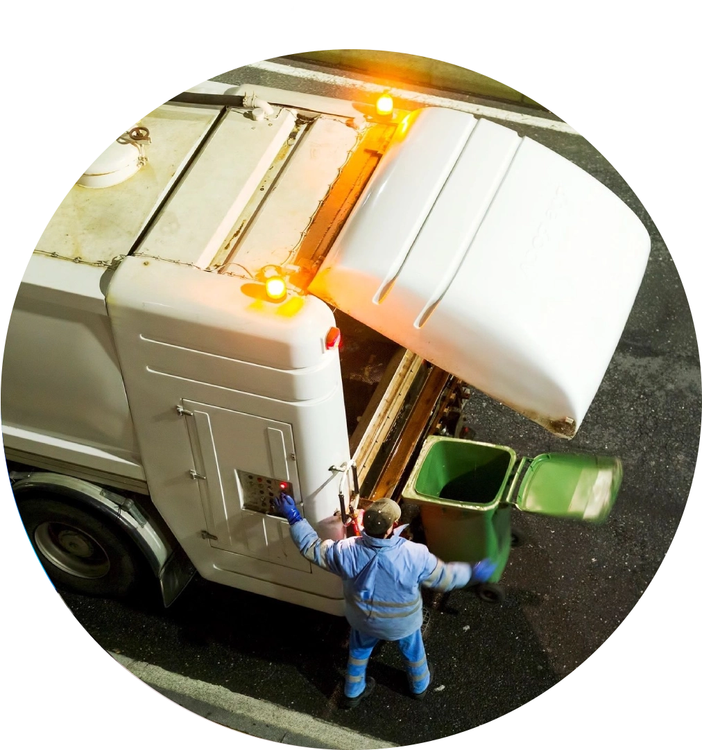 Garbage truck worker emptying a bin.